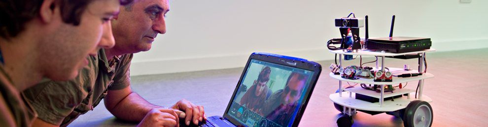 Two people with a laptop controlling a motorised webcam